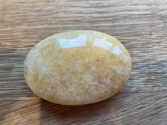 Orange calcite palm stone